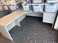 Overall view of L-shaped desk assembled against wall with pedestal