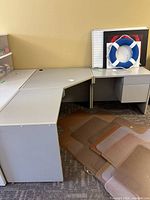 Overall view of assembled L-shaped gray desk with pedestal and items on top