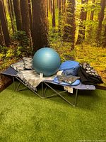 Overall lot showing cot, exercise ball, linens, clothing