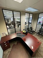 Full view of L-shaped desk assembled in office with floor mat underneath