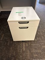 Front view showing two drawers, handles, casters