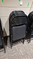 stack of black metal folding chairs folded