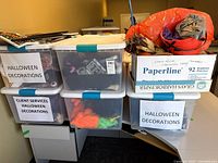 Three clear totes labeled Halloween Decorations with visible contents, plus box and bag of decorations