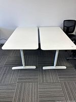 Top view of the two white Bekant tables side by side