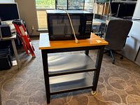Microwave sitting on rolling cart showing full view of both items