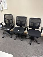Three black mesh office chairs side-by-side