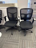 Two black mesh back office chairs side by side