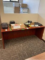 Front view of rectangular laminate desk with items on top (not included)