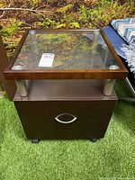 Front view showing glass top, drawer, casters