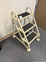 Full side view of cream metal 3-step ladder