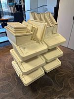 Stack of large and small white IKEA Sockerbit bins with lids and magazine holders