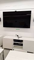 Front view of wall-mounted Samsung TV above media cabinet