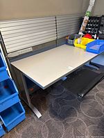 Full view of workstation desk showing laminate top, power strip, surrounding bins for scale