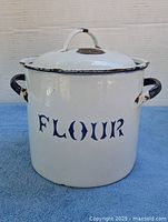 Front view showing lettering, handles, lid