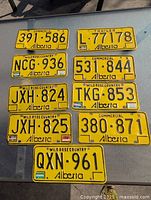 All nine yellow Alberta license plates laid out on a table