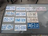 Overall view of all thirteen Ontario licence plates on table