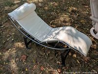 Side view of chrome chaise lounge showing frame, cushion, base