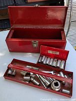 Overall view of red Husky toolbox with open lid, socket tray, socket box, and tools displayed