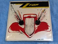 Full view of square ZZ Top Eliminator mirror on blue cloth background