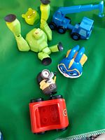 overview of toys: green creature, pig head, blue crane, blue mask figure, Minion, red block