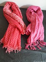 Two pink scarves laid out side by side