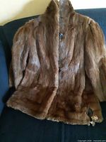 Front view of brown mink fur coat on sofa