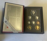 Photo of the 1997 Canadian coin set with seven coins displayed in individual slots and a certificate of authenticity visible.