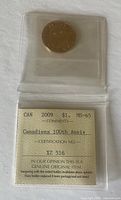Front view of 2009 Canadian $1 coin in plastic holder showing grading and anniversary details.