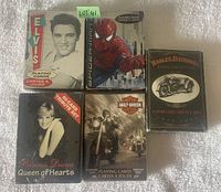 Five sealed decks of playing cards displayed showing themes of Elvis Presley, Spiderman, Harley Davidson, and Princess Diana.