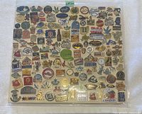 Display of approximately 90 assorted pins from multiple themes and countries including Canadian symbols, sports logos, cartoon icons, and more.