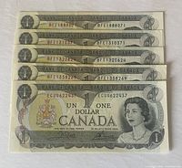 Five 1973 Canadian one-dollar bills arranged side-by-side, showing the front with serial numbers visible.