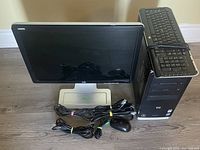 Photo showing HP monitor, keyboard, mouse, cables, and desktop tower placed on the floor.