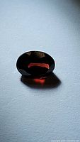 Oval cut cherry red garnet viewed from various angles showing rich color and faceting.