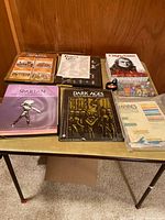 Photo showing the collection of game rulebooks and boxed sets including Spartan, Dark Ages, A Mighty Fortress, Frederick the Great, Napoleon's Last Battles, and Empires of the Middle Ages with counters and cards.