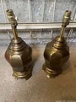 Pair of vintage brass table lamp bases with tarnishing and light surface wear, no shades or bulbs included