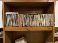 Wooden shelving unit holding approximately 300 vinyl records arranged vertically