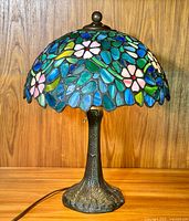 Full view of lamp on wooden background showing dome shade and bronze base