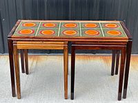 Front view of three rosewood nesting tables fully nested