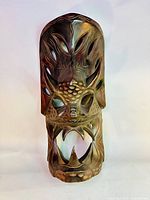 Front view of the carved wooden tribal dragon mask showing the mouth, teeth, and eye cutouts.