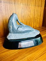 Side view of grey soapstone walrus sculpture on black wood base with engraved metal plaque showing 25 Year Service award and personalized name.