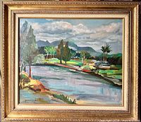 Full frontal view of the painting showing a richly framed oil on canvas landscape with a river, trees, and mountains under cloudy sky with signature visible.