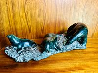 Front view showing three seal figures on a textured base