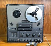 Front view of Philips N4504 stereo reel-to-reel tape recorder with one reel loaded and all knobs, meters and switches visible.