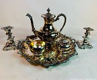 Full view of the silverplated coffee set arranged on the decorative tray with two matching candlesticks on the side, showing overall condition and style.