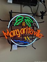 Front view of fully illuminated neon sign mounted on metal frame.