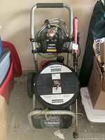 Full view of the Husky pressure washer with hose, spray wand, and Kärcher surface cleaner attached, showing the overall unit configuration and branding.