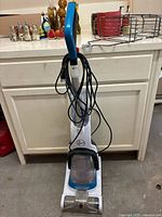 Front view of Hoover Power Dash Pet upright vacuum showing handle, cord wrapped around, and dust collector bin.