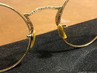 Close-up of ornate gold C-bridge and yellow nose pads