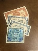 Four WWII era banknotes laid out showing denominations and issuing authorities