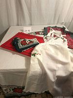 Overall lot showing tablecloth on table, placemats, folded napkins, and two aprons
